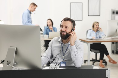 Photo of Technical support call center. Team of operators working in office