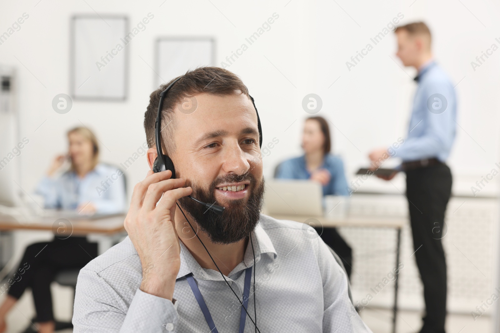 Photo of Technical support call center. Smiling operator working in office