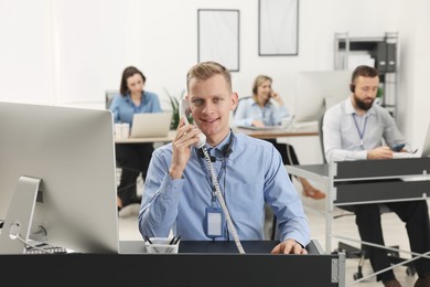 Photo of Technical support call center. Team of operators working in office