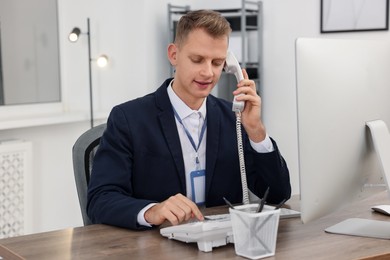 Photo of Technical support call center. Operator working at table in office