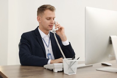 Photo of Technical support call center. Operator working at table in office