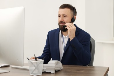 Photo of Technical support call center. Operator working at table in office