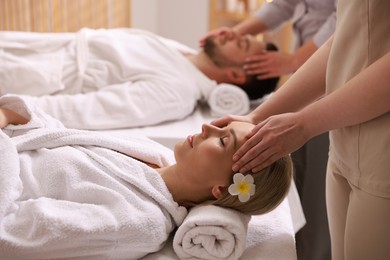 Photo of Couple receiving relaxing massage in spa salon, selective focus