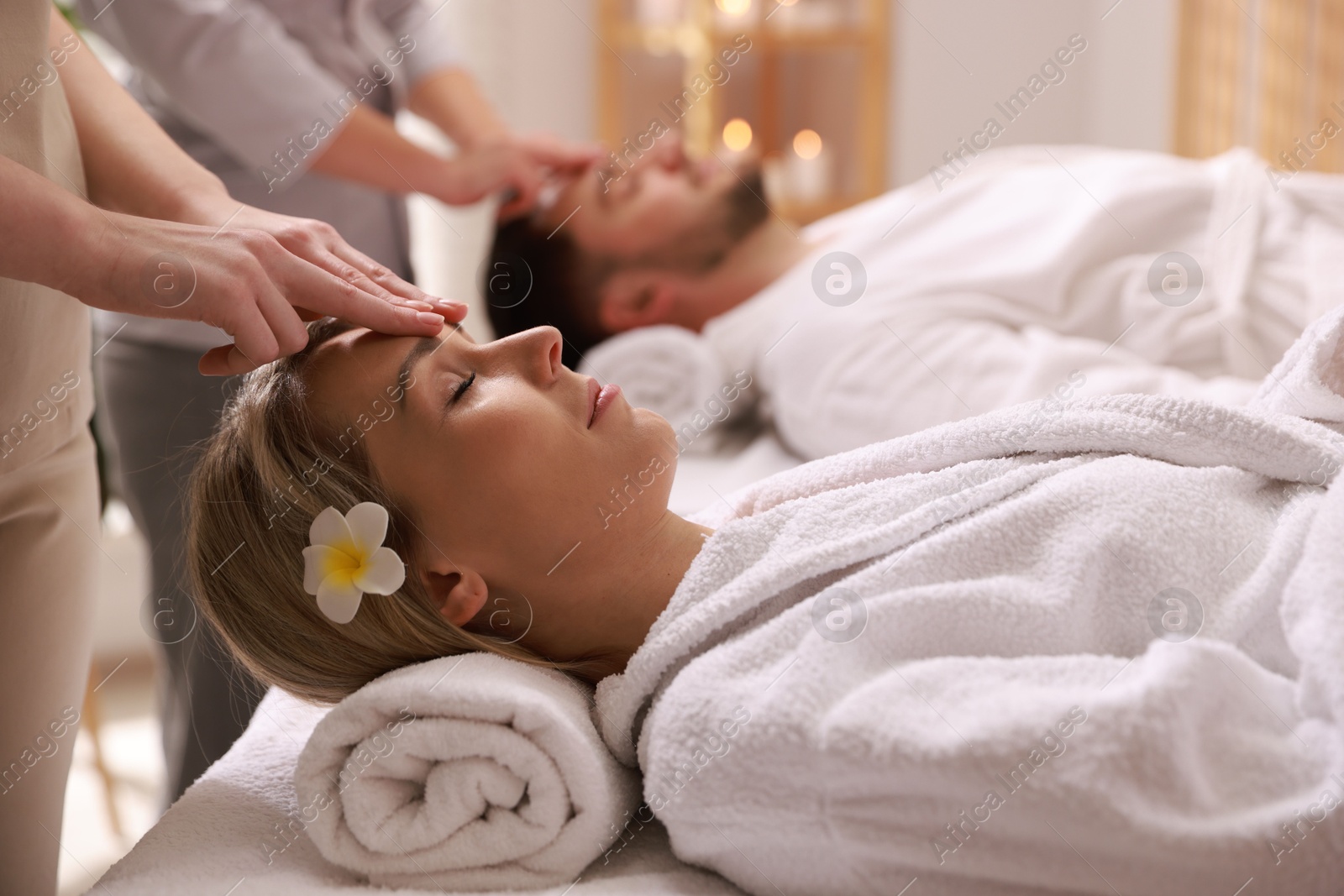 Photo of Couple receiving relaxing massage in spa salon, selective focus