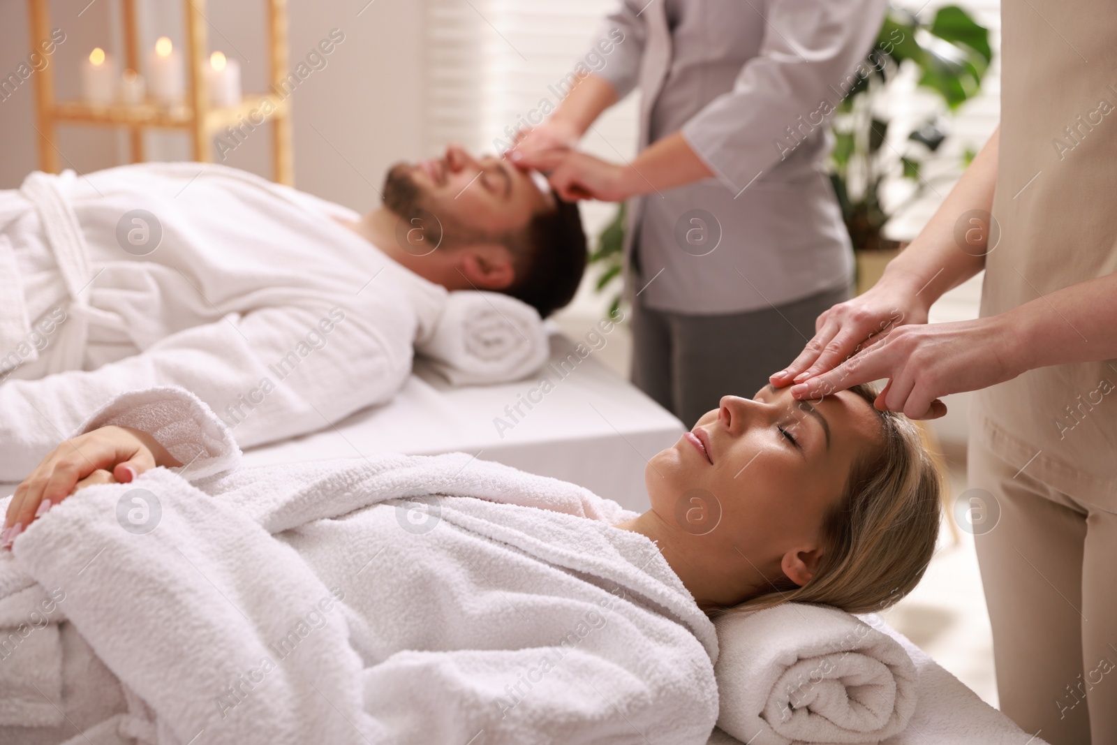 Photo of Couple receiving relaxing massage in spa salon, selective focus