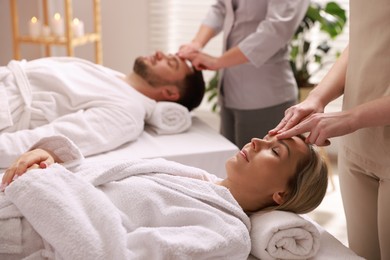 Photo of Couple receiving relaxing massage in spa salon, selective focus