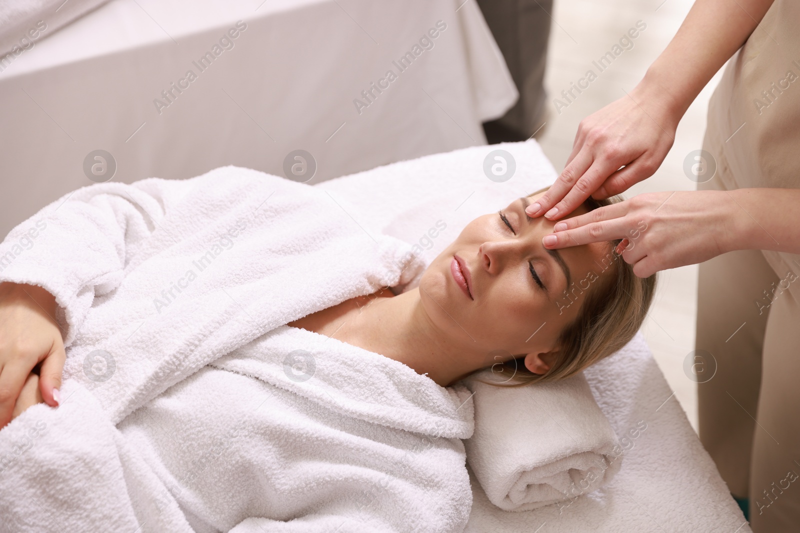 Photo of Woman receiving relaxing facial massage in spa salon