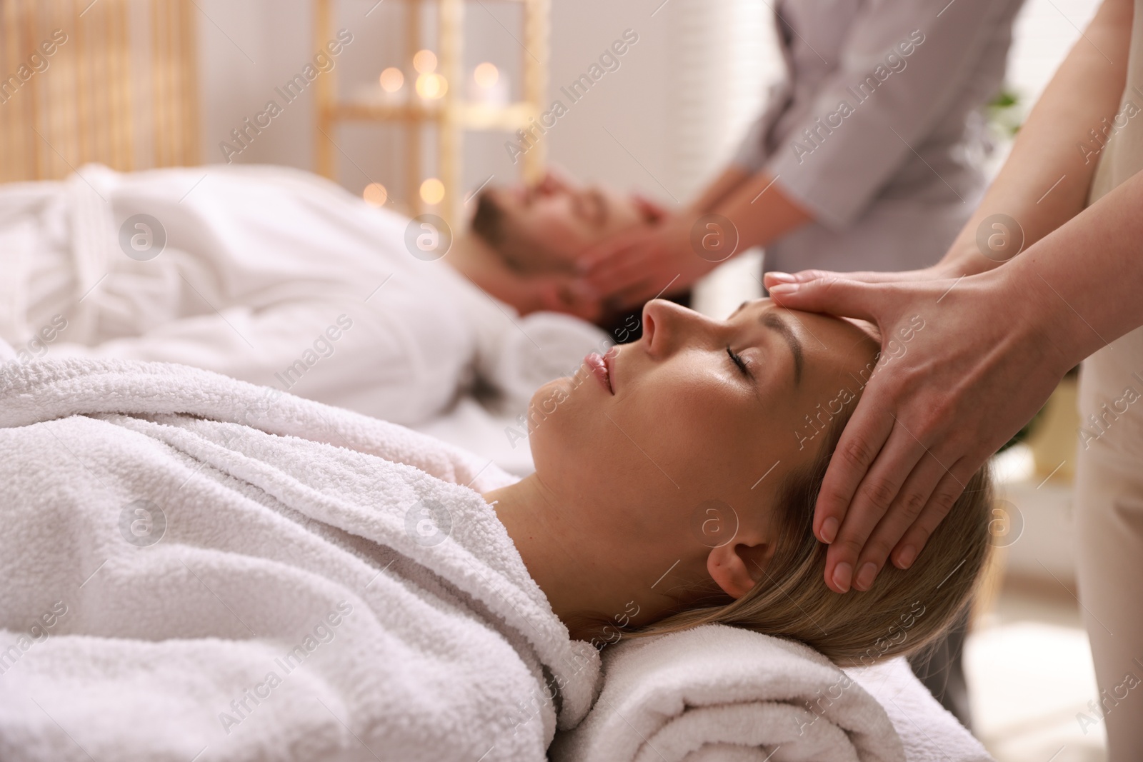 Photo of Couple receiving relaxing massage in spa salon, selective focus