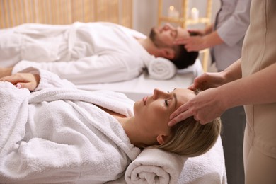 Photo of Couple receiving relaxing massage in spa salon, selective focus