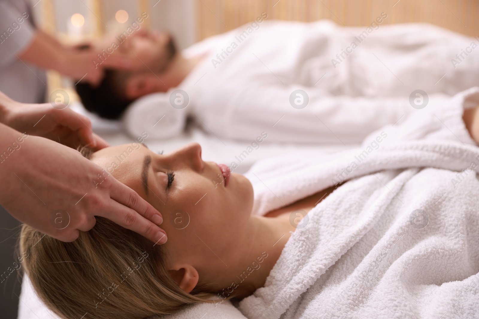 Photo of Couple receiving relaxing massage in spa salon, selective focus