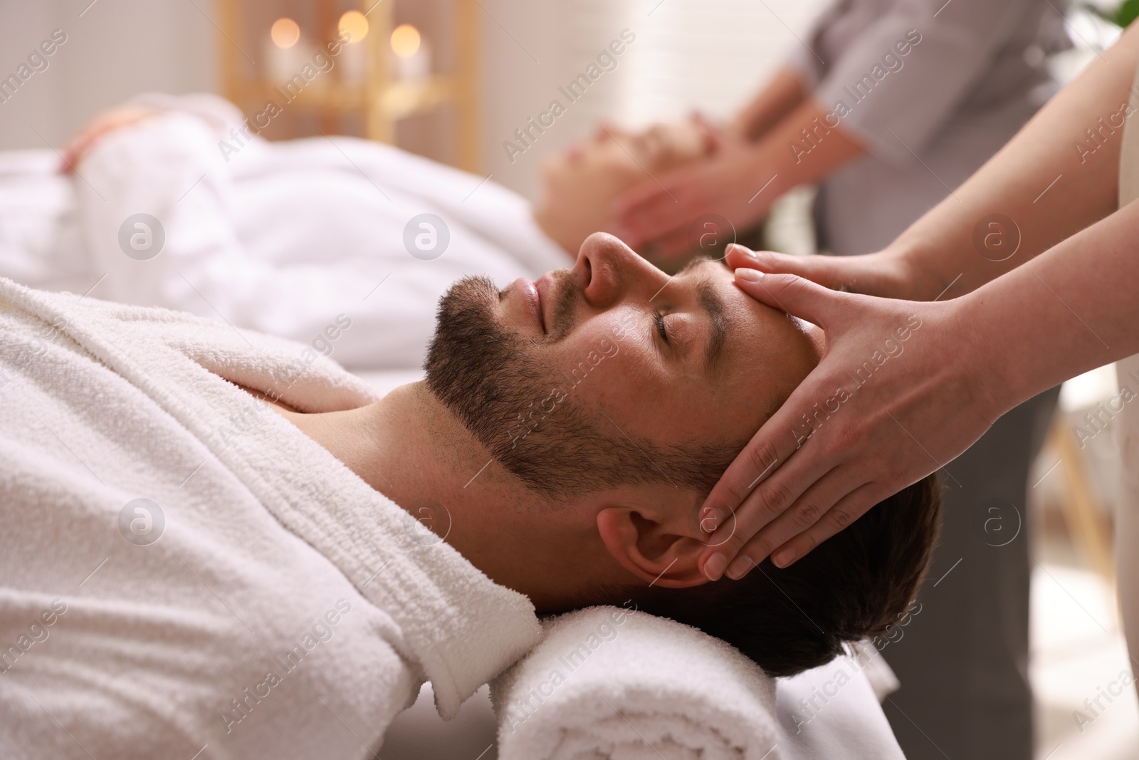 Photo of Couple receiving relaxing massage in spa salon, selective focus