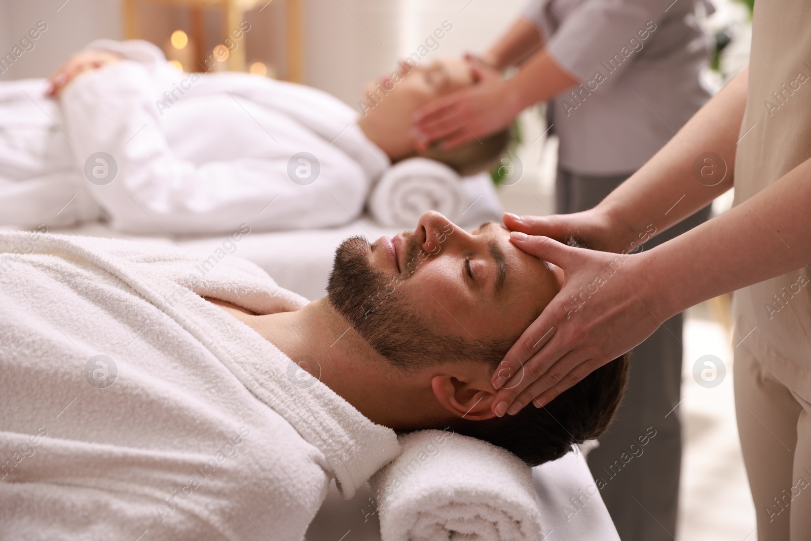 Photo of Couple receiving relaxing massage in spa salon, selective focus