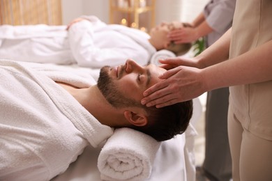 Photo of Couple receiving relaxing massage in spa salon, selective focus