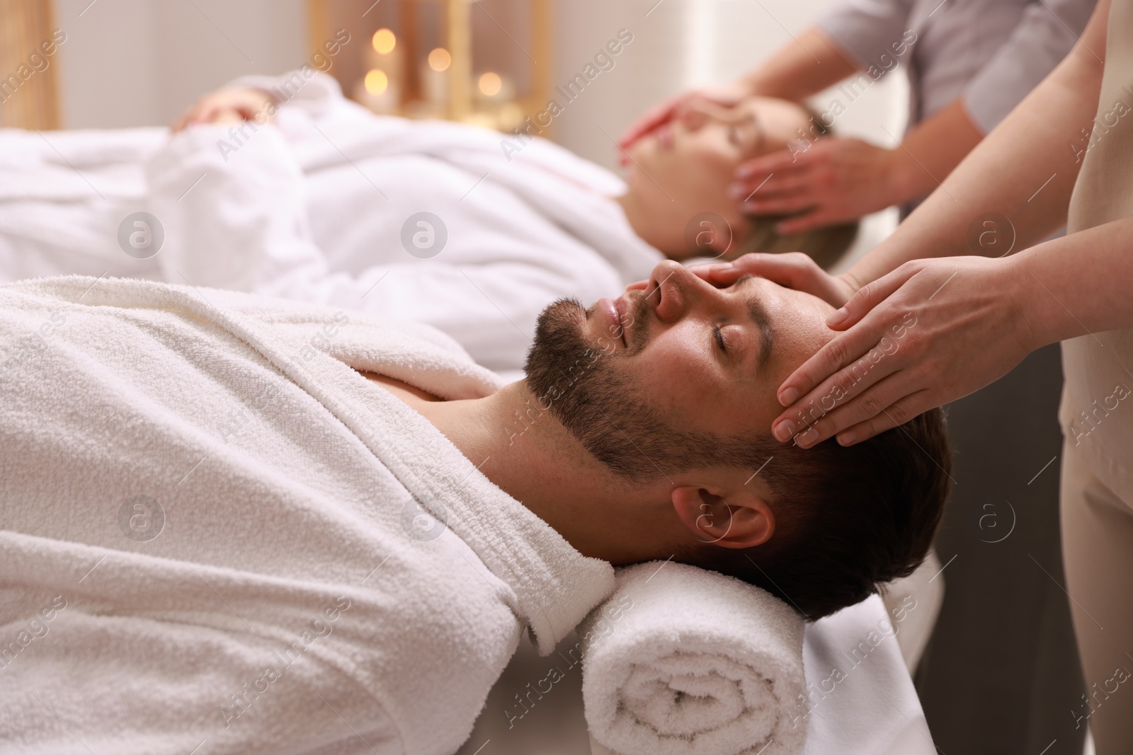 Photo of Couple receiving relaxing massage in spa salon, selective focus