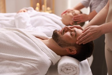 Photo of Couple receiving relaxing massage in spa salon, selective focus