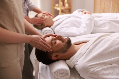 Photo of Couple receiving relaxing massage in spa salon, selective focus