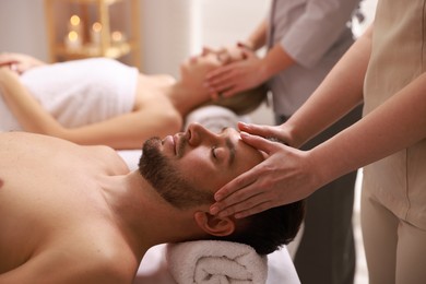 Photo of Couple receiving relaxing massage in spa salon, selective focus