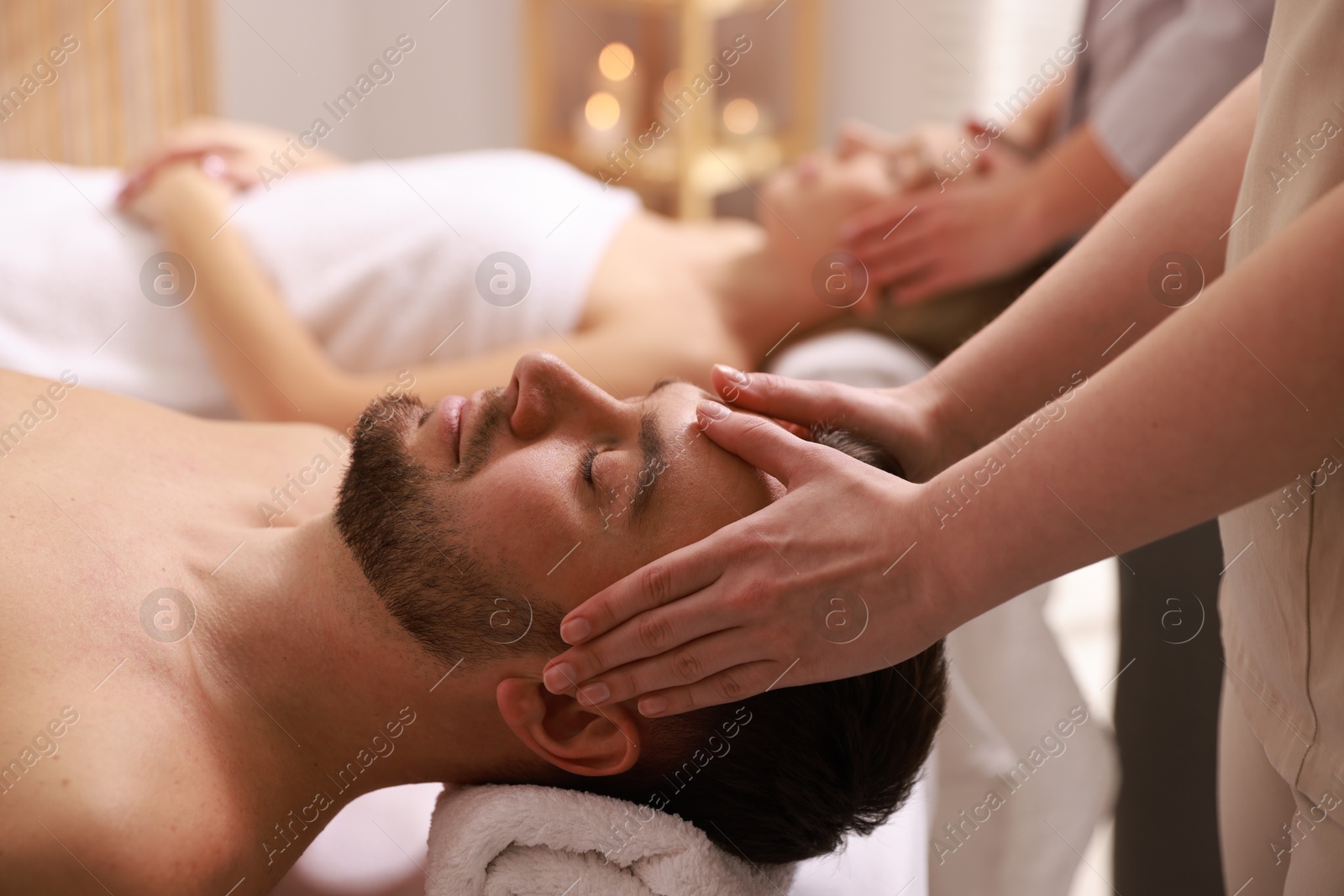 Photo of Couple receiving relaxing massage in spa salon, selective focus