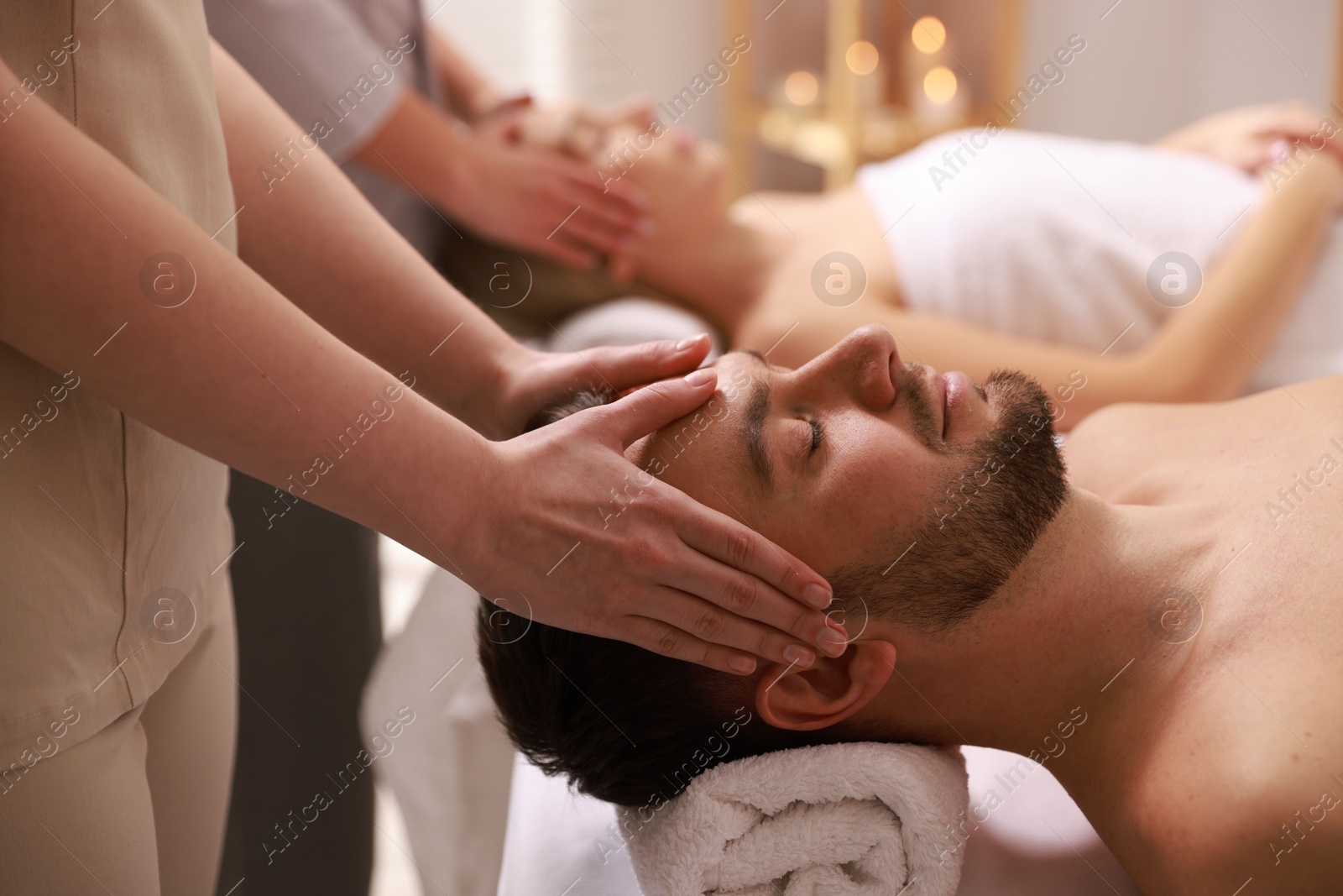 Photo of Couple receiving relaxing massage in spa salon, selective focus