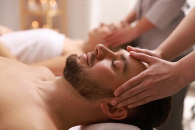 Photo of Couple receiving relaxing massage in spa salon, selective focus