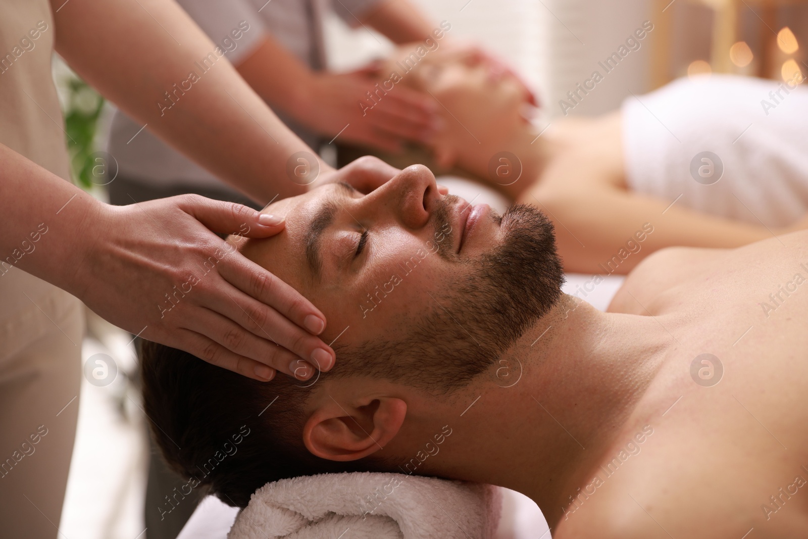 Photo of Couple receiving relaxing massage in spa salon, selective focus