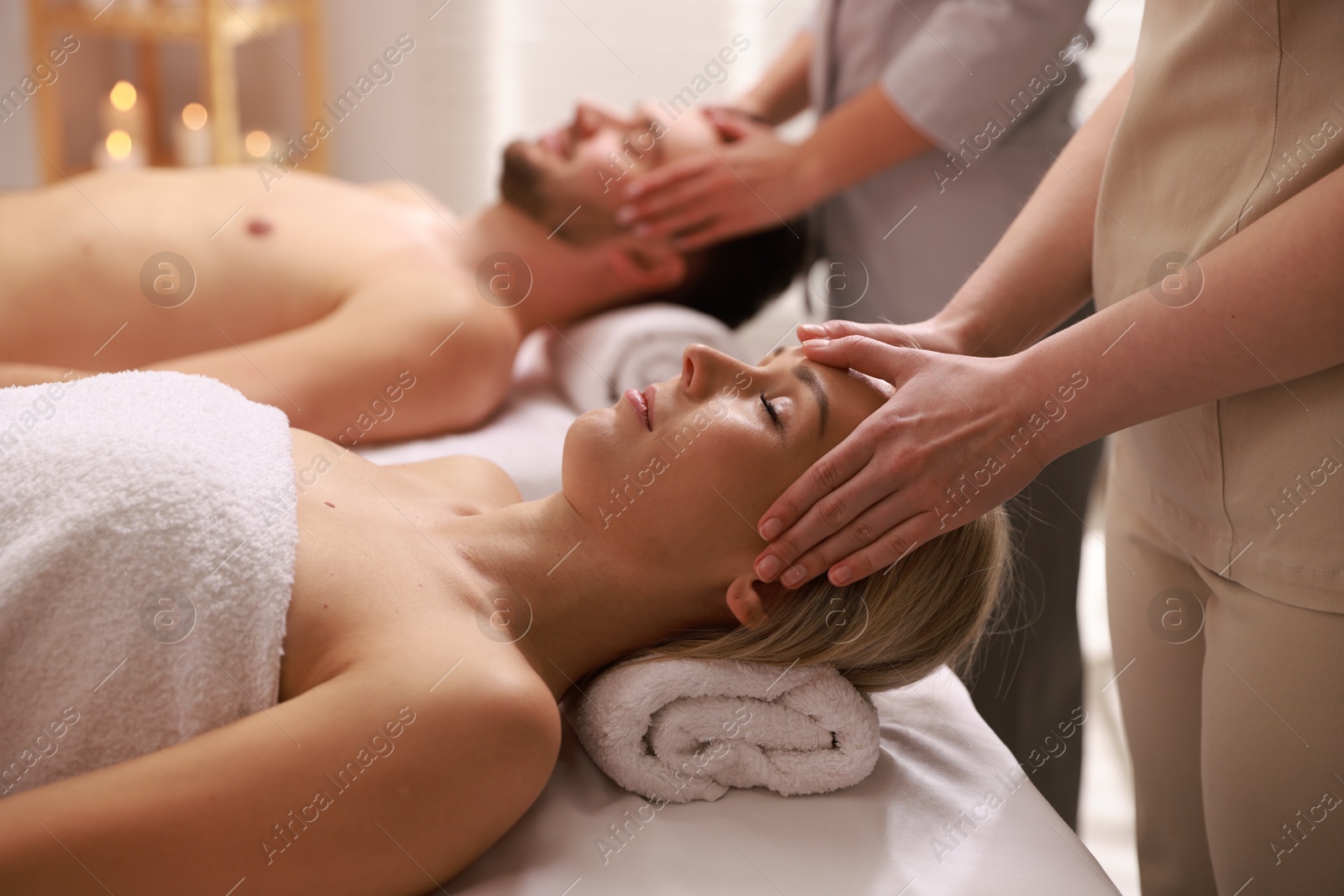 Photo of Couple receiving relaxing massage in spa salon, selective focus