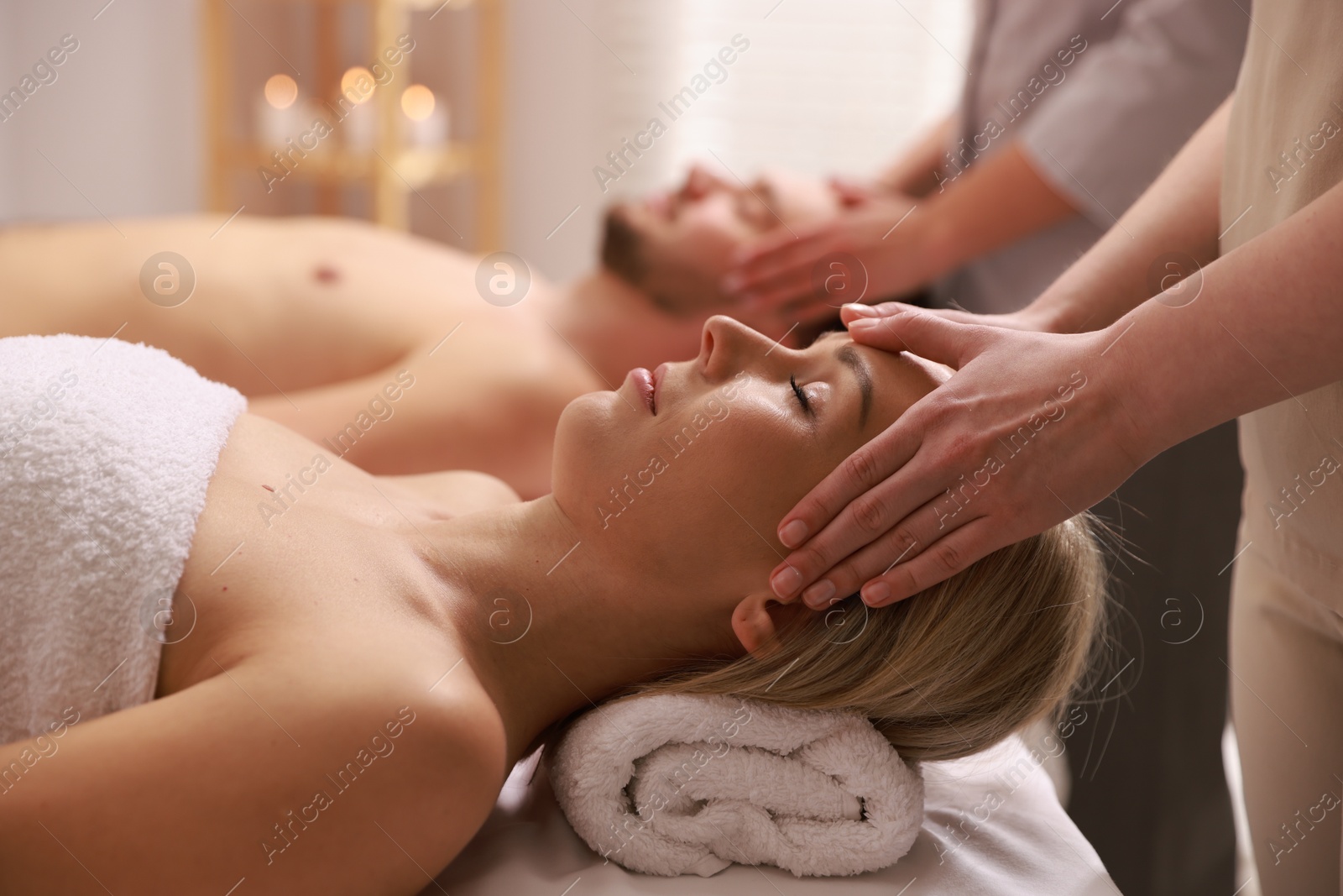 Photo of Couple receiving relaxing massage in spa salon, selective focus