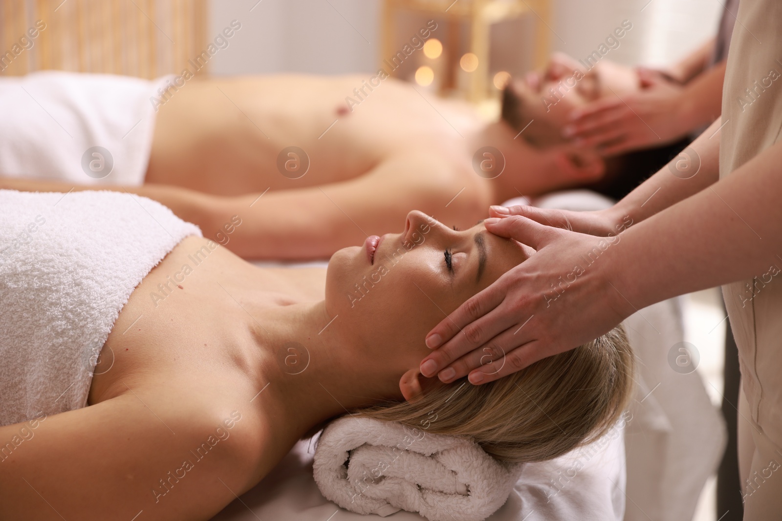 Photo of Couple receiving relaxing massage in spa salon, selective focus