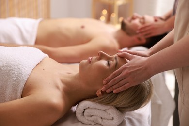 Photo of Couple receiving relaxing massage in spa salon, selective focus