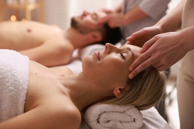 Photo of Couple receiving relaxing massage in spa salon, selective focus