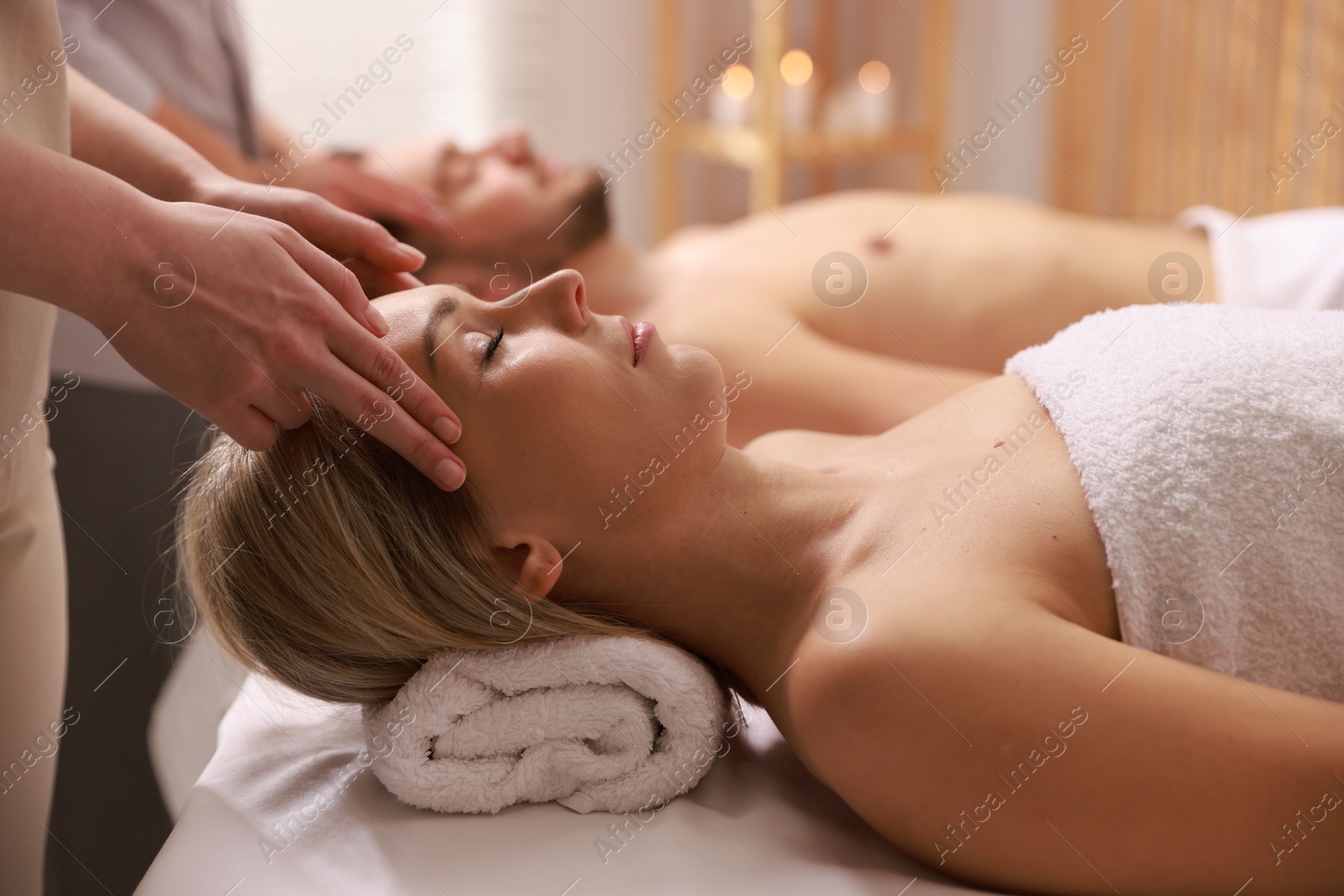 Photo of Couple receiving relaxing massage in spa salon, selective focus