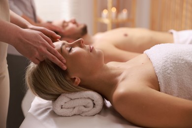 Photo of Couple receiving relaxing massage in spa salon, selective focus