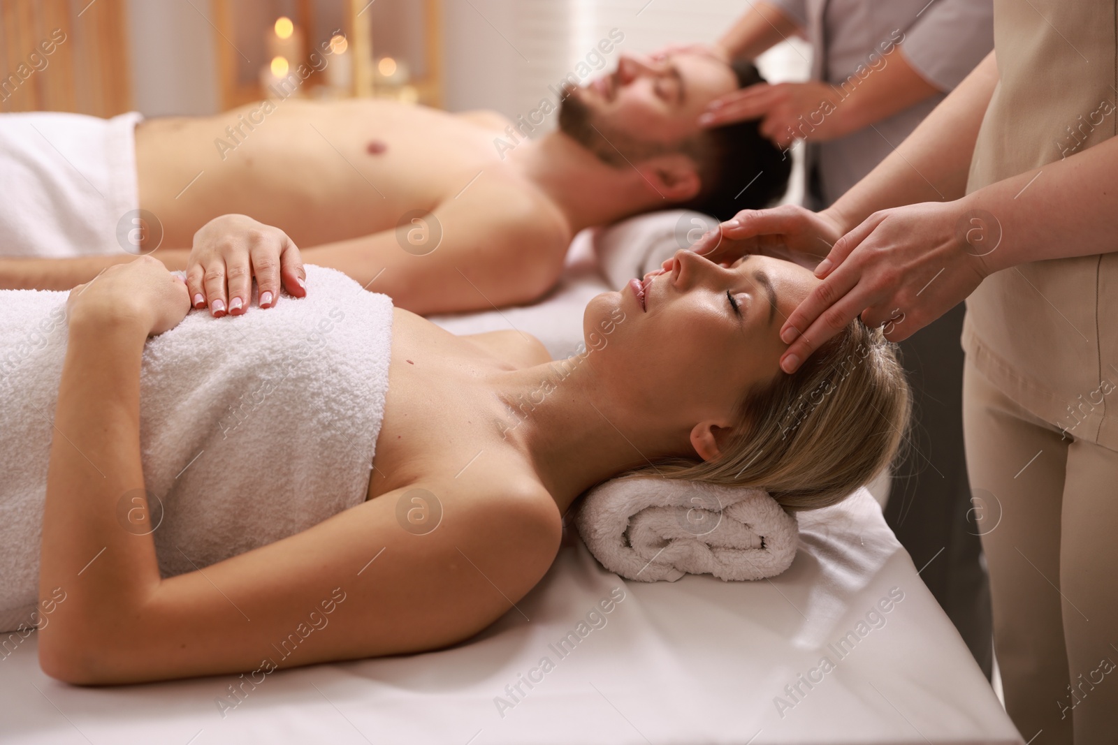 Photo of Couple receiving relaxing massage in spa salon, selective focus