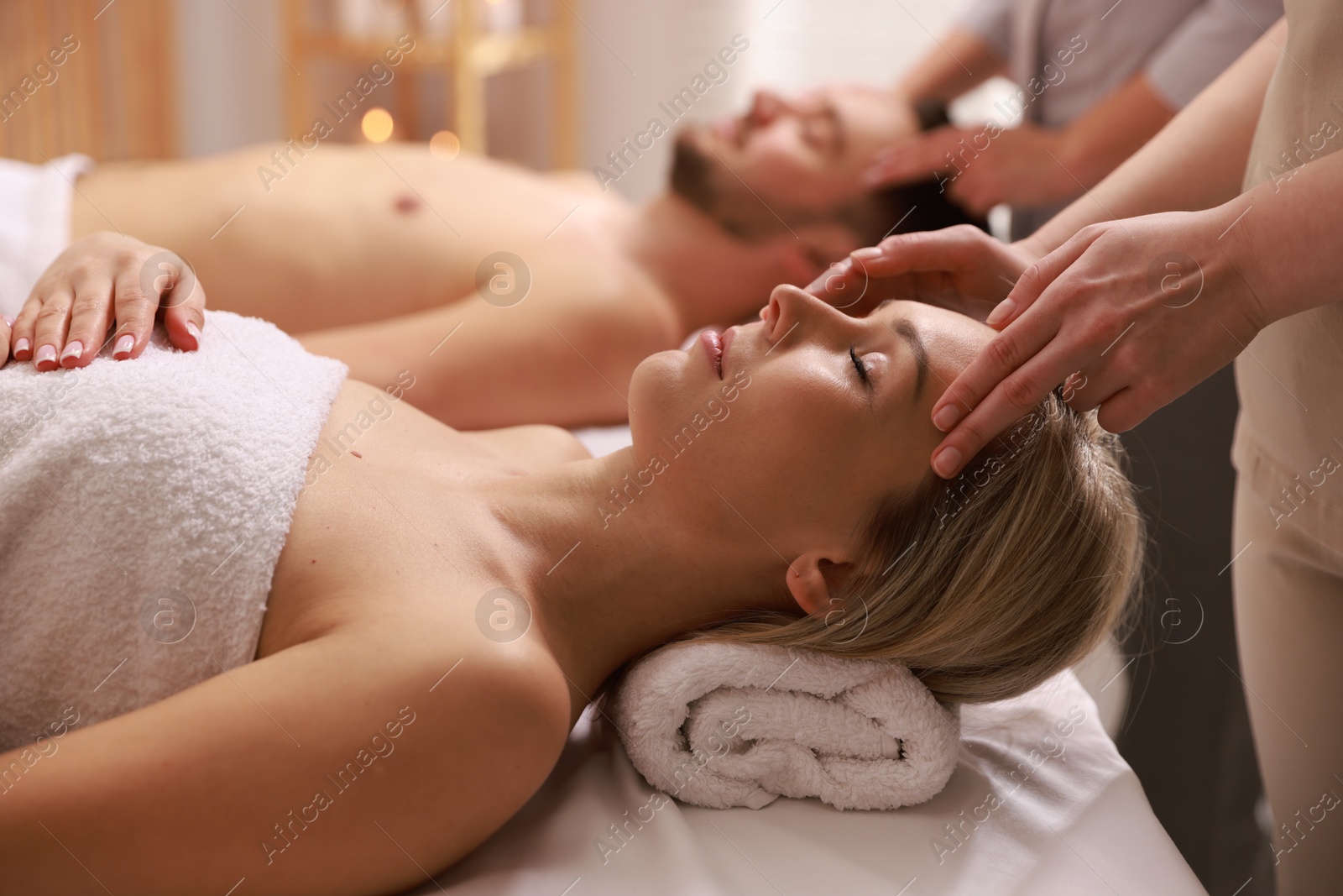 Photo of Couple receiving relaxing massage in spa salon, selective focus