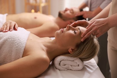 Photo of Couple receiving relaxing massage in spa salon, selective focus