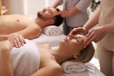 Photo of Couple receiving relaxing massage in spa salon, selective focus