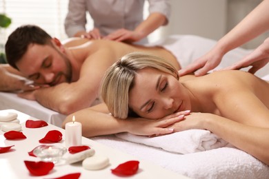 Photo of Couple receiving relaxing massage in spa salon, selective focus