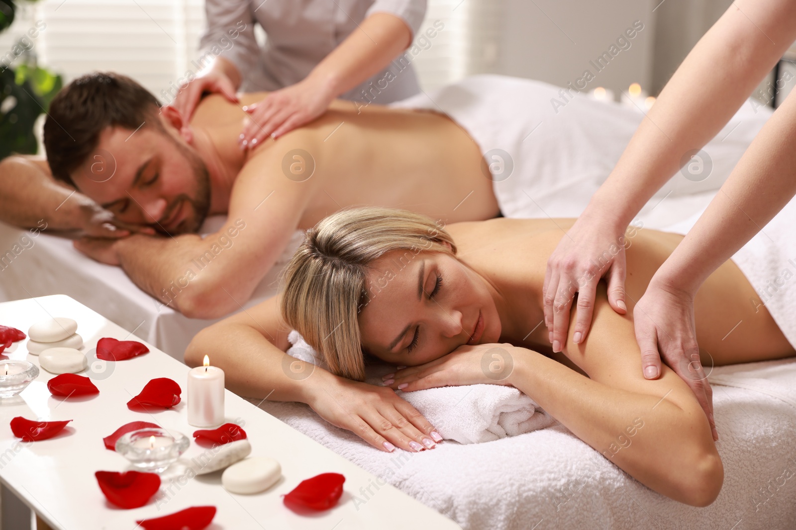 Photo of Couple receiving relaxing massage in spa salon, selective focus