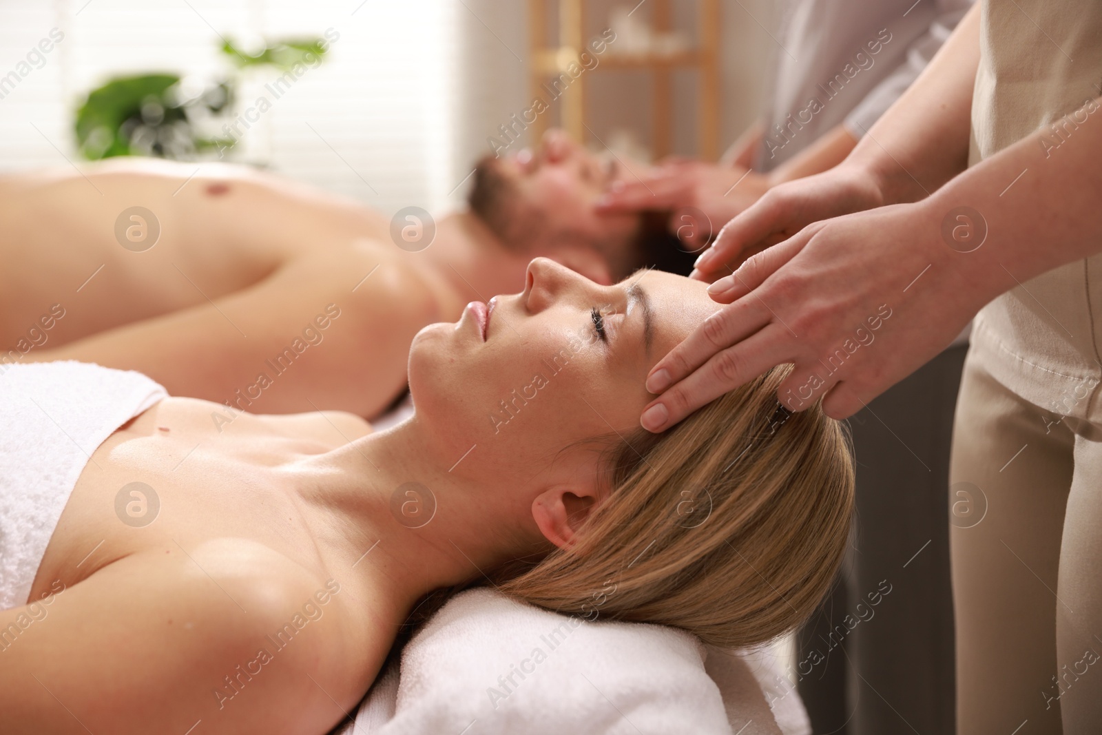 Photo of Couple receiving relaxing massage in spa salon, selective focus