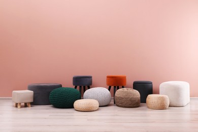 Photo of Different stylish poufs and ottomans near pink wall, space for text