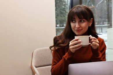 Photo of Beautiful woman having coffee break in cafe. Space for text