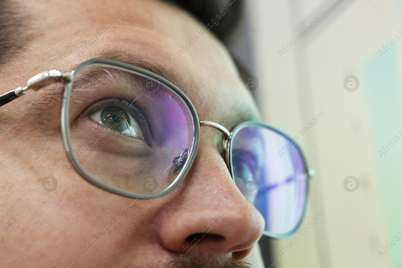 Photo of Man wearing stylish glasses on blurred background, closeup