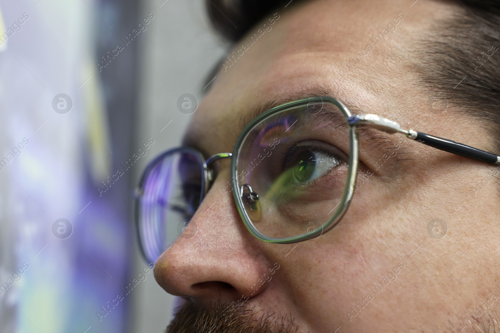 Photo of Man wearing stylish glasses on blurred background, closeup