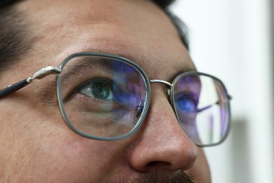 Photo of Man wearing stylish glasses on blurred background, closeup