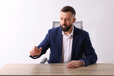 Photo of Man pointing at something at wooden desk in office