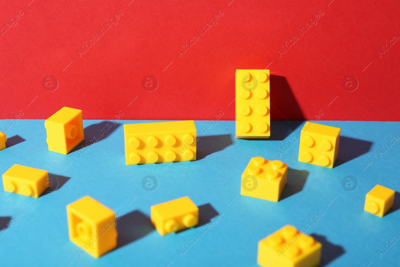 Photo of Construction toy. Bright building bricks on color background, closeup