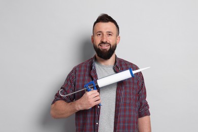 Photo of Man with caulking gun on gray background