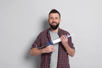 Photo of Man with caulking gun on gray background