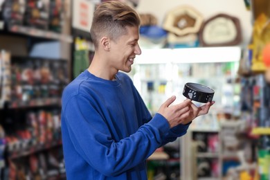 Photo of Happy man with feeding bowl in pet shop