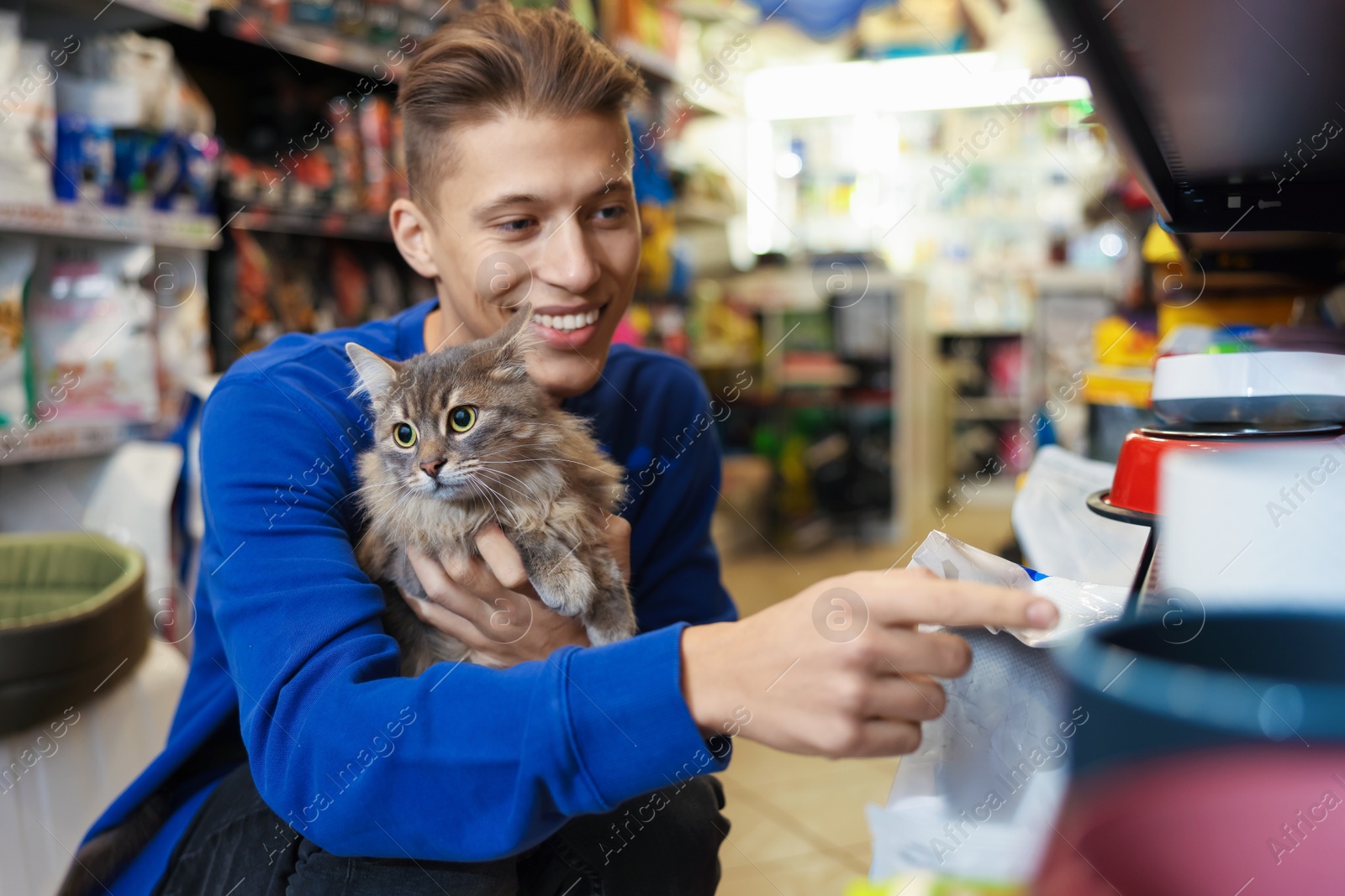 Photo of Man with his cute cat in pet shop